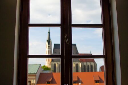 Defocused image of the facade of St. Vitus Church through a window from inside of a house in Cesky...