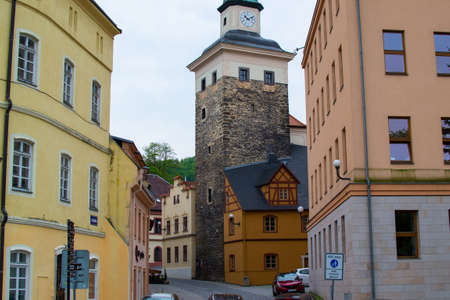 Loket, Czech Republic; 5/20/2019: View of the Black Tower (Cerna Vez) between some typical colorful...