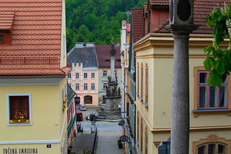 Loket, Czech Republic; 5/20/2019: View of the Holy Trinity Column between typical colorful czech...