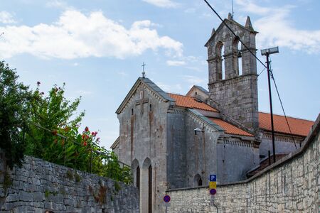 Church and Monastery of St. Francis, with stone walls on both sides and the sky at the background, in Pula, Croatiaの写真素材