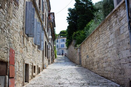 Picture of a narrow colorful stone street in the old town of Pula, Croatia, with steps at the backgroundの写真素材