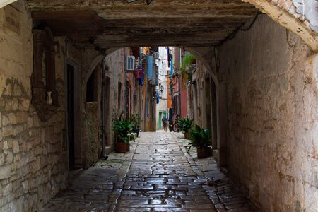 Picturesque arch with a colorful street at the background in the old town of Rovinj, Croatiaの写真素材