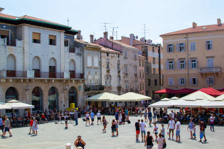 Forum Square, the main square in the old town of Pula, Croatia, with colorful buildings and people walking during a summer dayのeditorial素材