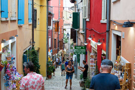 Rovinj, Croatia; 7/18/2019: Picturesque narrow street with colorful facades of the houses and people walkingのeditorial素材