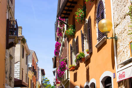 Porec (Parenzo), Croatia; 7/19/19: View of traditional colorful croatian buildings with flower pots in the windows, in the old town of Porec (also called Parenzo), Croatiaのeditorial素材