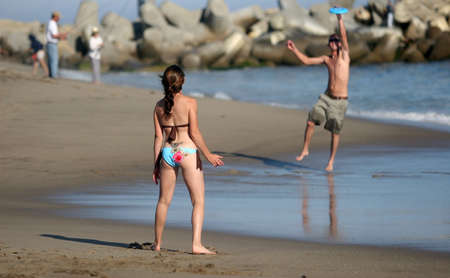 Couple playing frisbee on the beach