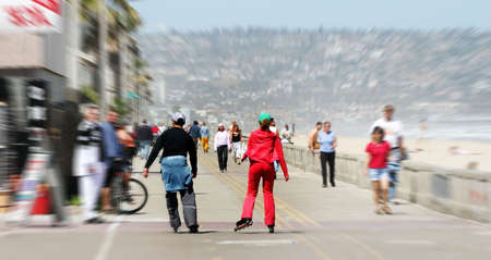 Couple rollerblading along the beach with motion blurの写真素材