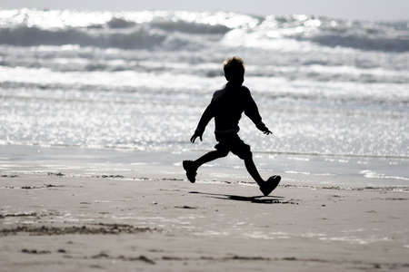 Boy running on the beachの写真素材