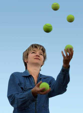 Woman juggling with tennis ballsの写真素材