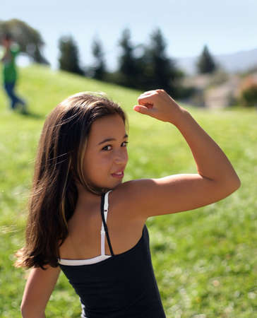 Teenage girl showing her musclesの写真素材