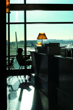 Woman reading in airport cafeの写真素材