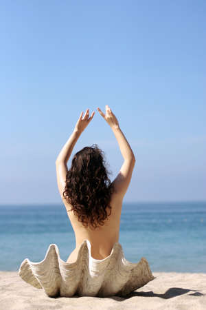 Girl in sea shell on the beachの写真素材
