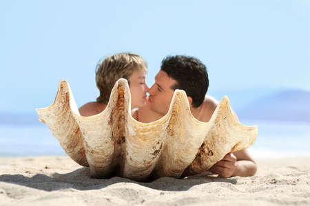 Romantic couple on the beach behind the seashellの写真素材