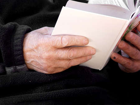 Hands of an old man holding a bookの写真素材