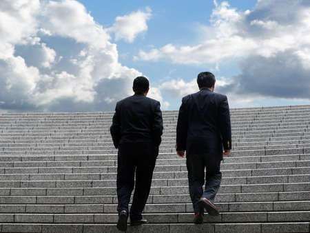 Two business men walking up the stairsの写真素材