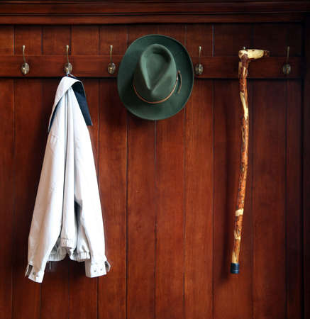 Still life od a wooden clothes rack with a hat,jacket and a caneの写真素材