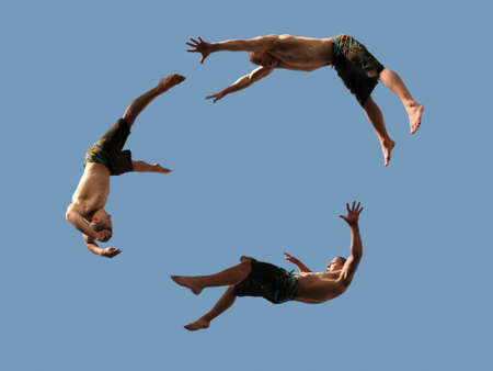 A cirlcle of three flying young athletic menの写真素材