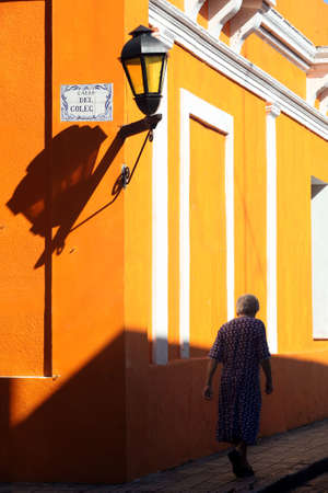 Elderly lady walking on the street in Colonia, Uruguay の写真素材