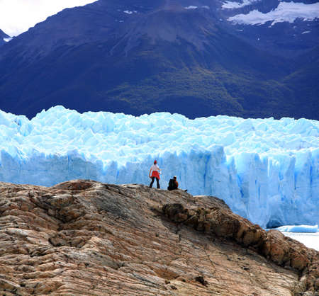 Couple looking at Perito Moreno Glacier, Patagonia, Argentinaの写真素材