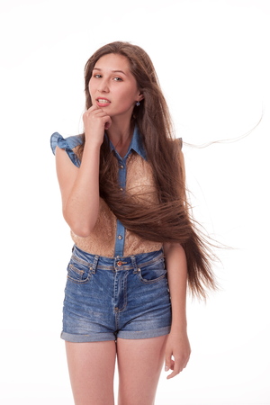 Beautiful girl dancing in the camera, posing against white background. Different poses and emotions. Standing, moving, smiling. playful dances, choreography. Brunette with long hair, slender, cheerful and charismaticの写真素材