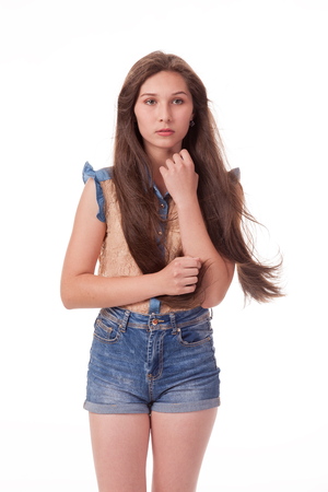 Beautiful girl dancing in the camera, posing against white background. Different poses and emotions. Standing, moving, smiling. playful dances, choreography. Brunette with long hair, slender, cheerful and charismaticの写真素材