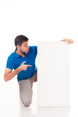 A guy with a beard posing with a white sign, isolated on a white background.の写真素材