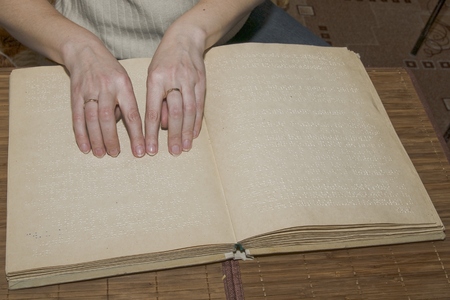Blind man reads Braille bookの写真素材