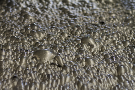 Bubbles on surface of copper froth flotation process, separating valuable mineral from waste, as...