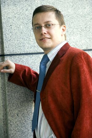 Businessman, young, handsome and successful man. Wearing red suit and blue tie.の写真素材