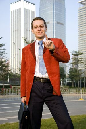 Young, successful European businessman in modern Chinese city. Wearing red suit.の写真素材