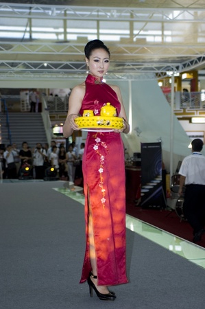CHINA, GUANGDONG, SHENZHEN - MAY 16, 2009: China Cultural Industries Fair: beautiful Chinese hostess present Chinese porcelain, ceramic tea sets, vases, pots, plates.のeditorial素材