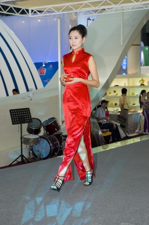 CHINA, GUANGDONG, SHENZHEN - MAY 16, 2009: China Cultural Industries Fair: beautiful Chinese hostess present Chinese porcelain, ceramic tea sets, vases, pots, plates.のeditorial素材