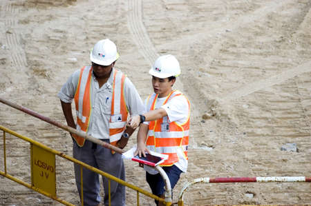 HONG KONG - OCTOBER 30: Two engineers discuss about construction plan, building another island in Hong Kong Central on October 30, 2008 in Hong Kong.のeditorial素材