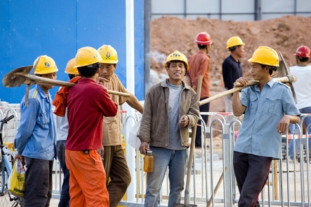 CHINA, SHENZHEN - NOVEMBER 24: Workers from all around China are building Shenzhen metro, group of workers having break for cigarettes on October 24, 2008 in Shenzhen, China.のeditorial素材