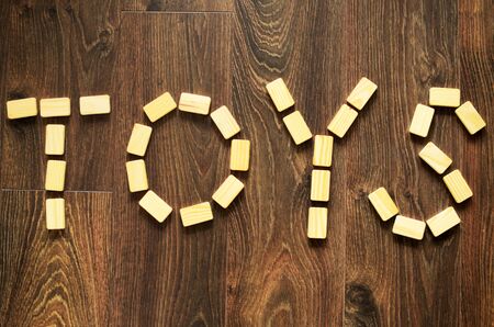 Word toys arranged by wooden blocks on wooden, brown floor.の写真素材