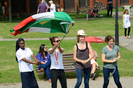 TRZEBNICA, POLAND - JULY 25: World Youth Day, pilgrims cheering with Italian and Brazilian flag in front of St. Jadwiga Sanctuary on 25th July 2016 in Trzebnica.のeditorial素材