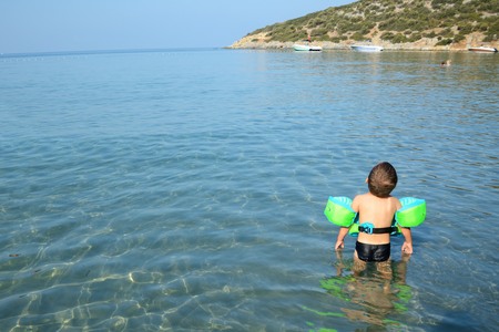 Holiday resort in Kusadasi, Turkey. Small boy, three years old playing in the water with safety equipment.の写真素材