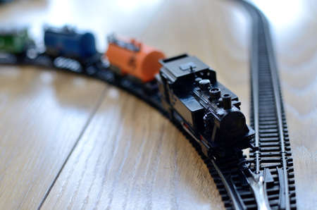 Miniature toy train, black locomotive with cars on metal rails, scale 1: 120. Vintage toy from 80's.