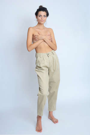 Young Polish woman in studio. Slim woman with dark hairs, topless with covered breasts.の写真素材