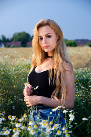 Beautiful, young woman posing for outdoor photos. Summer in Poland, woman surrounded by flowers.の写真素材