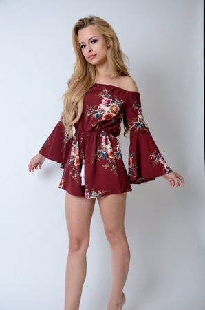 Beautiful woman in studio with white background. Polish model with dark red skirt with flowers.の写真素材
