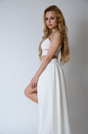 Polish model posing with white top, long white dress with cut, showing her legs.の写真素材