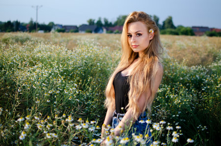 Beautiful, young woman posing for outdoor photos. Summer in Poland, woman surrounded by flowers.の写真素材