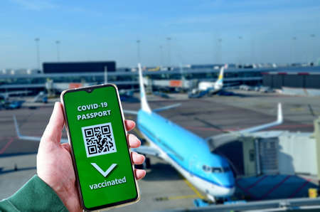 Traveling during SARS-CoV-19 pandemic. Waiting at airport with Covid-19 passport application in...