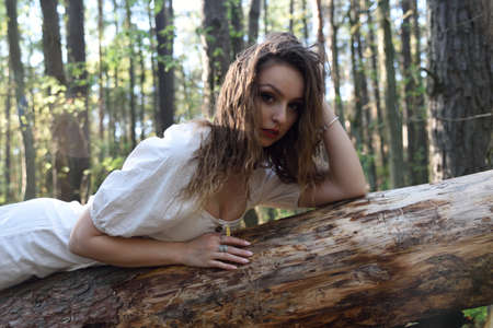 Pretty, young woman posing in the forest. Green surroundings during spring in Poland.の写真素材