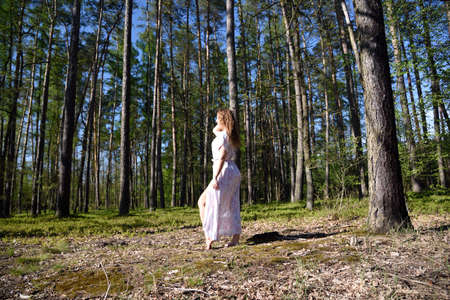 Pretty, young woman posing in the forest. Green surroundings during spring in Poland.の写真素材