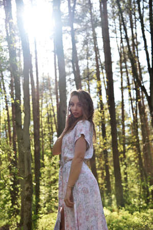 Pretty, young woman posing in the forest, wearing white dress. Green surroundings during spring in Poland.の写真素材