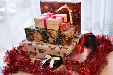 Christmas season approching. Colorful gift boxes, packed presents with Christmas style packing paper and ribbons.の写真素材