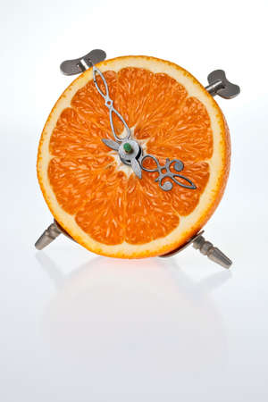 An orange, cut in half, made to be a clock.の写真素材