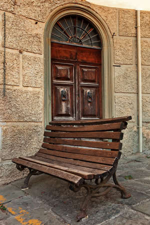 A door with bench standing next to it.の写真素材